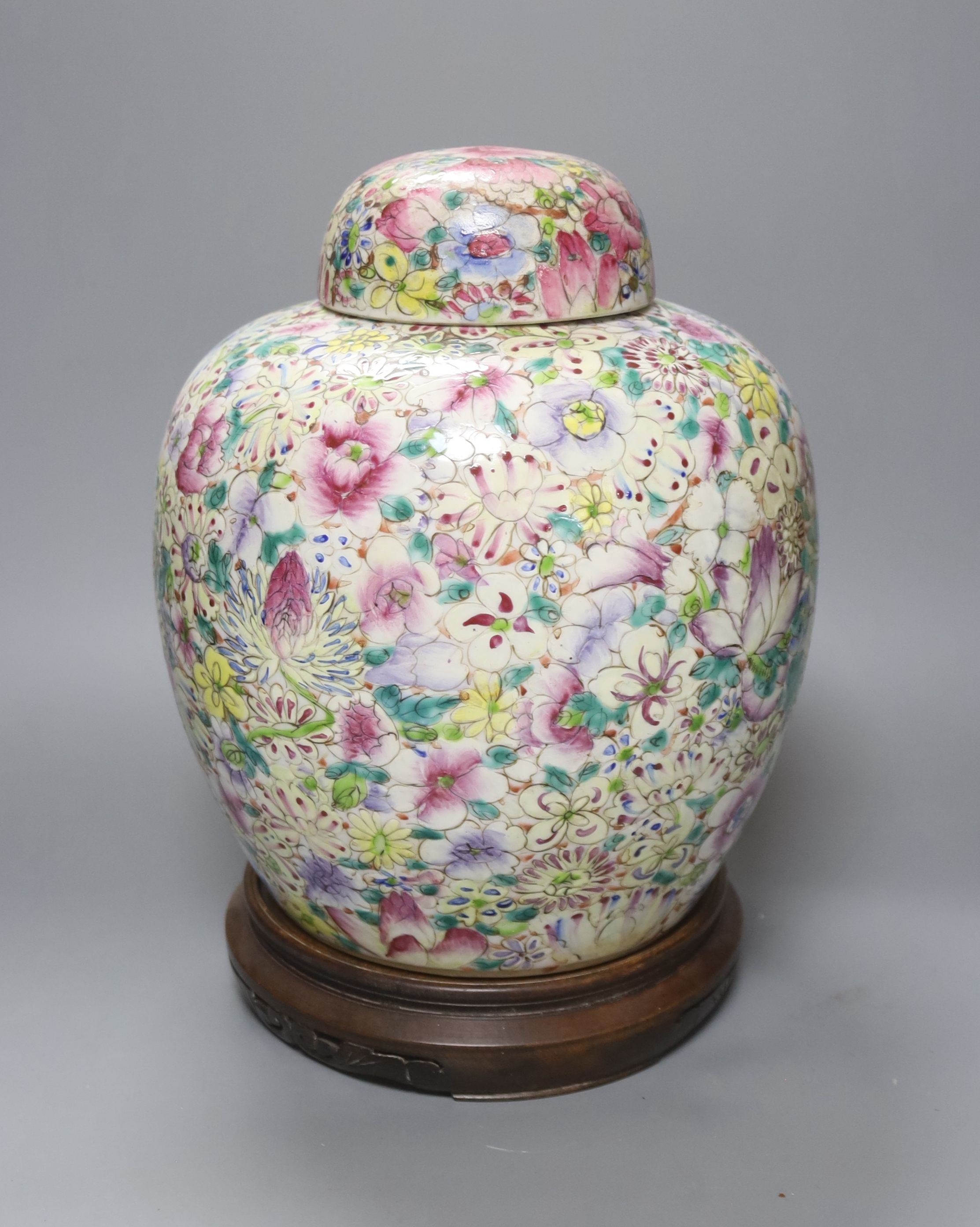 A Chinese thousand flower famille rose jar and cover, early 20th century, wood stand 28cm
